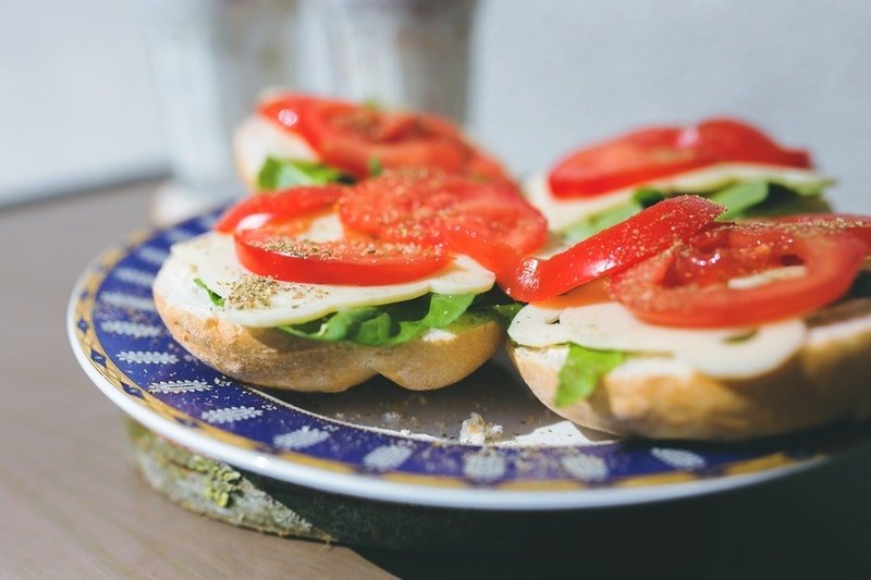 Fingerfood Sandwiches mit Käse Salat und Tomate auf einem Teller