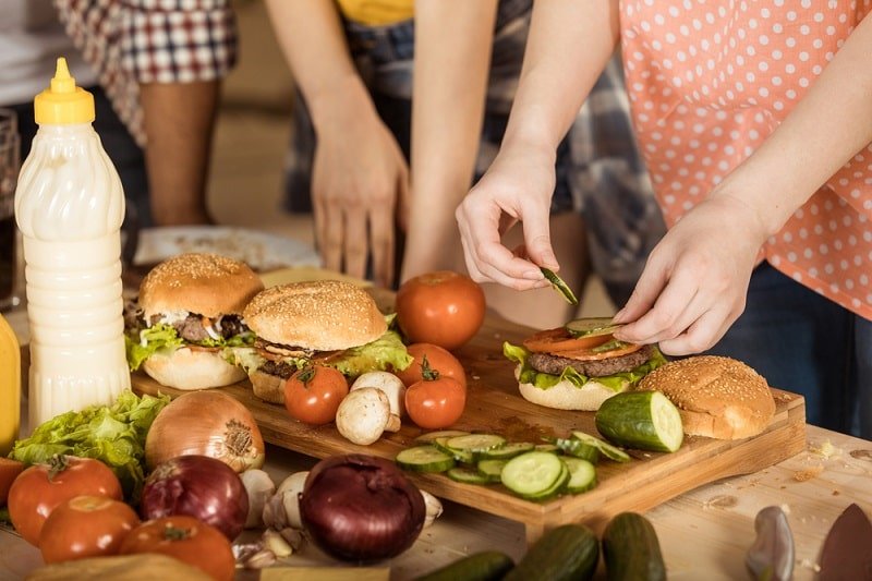 Frau-bereitet-Hamburger-auf-Küchenbrett Frau-bereitet-Hamburger-auf-Küchenbrett