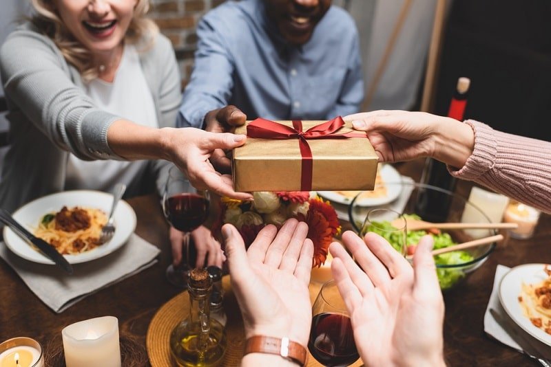 Leute, die Geschenke über Esstisch übergeben