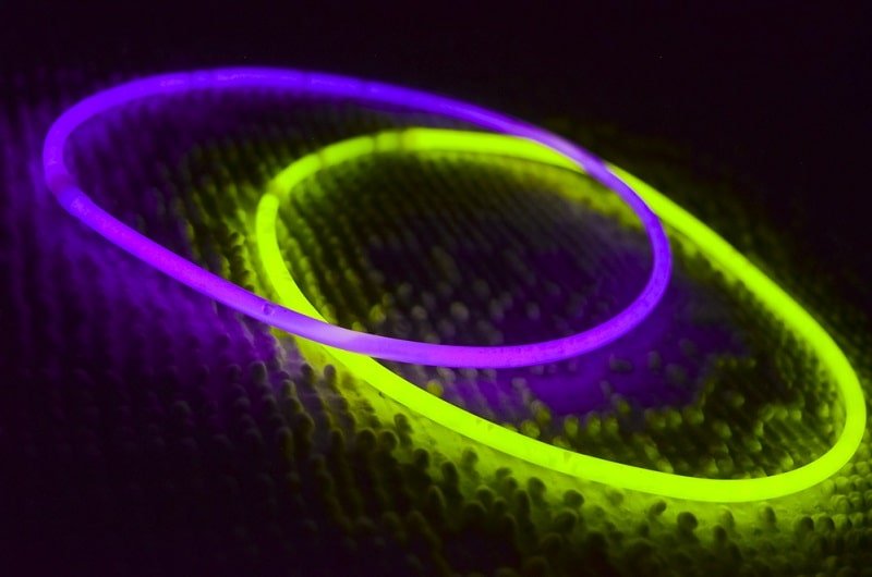 Lila und grün leuchtende Ringe im Dunkeln