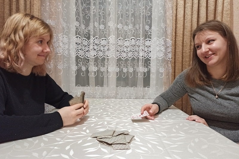 Zwei Mädchen spielen Karten am Tisch