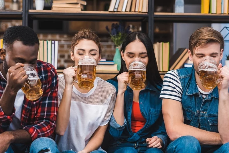 junge Freunde sitzen zusammen und trinken Bier