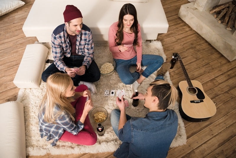 Draufsicht von Männern und Frauen spielen Karten