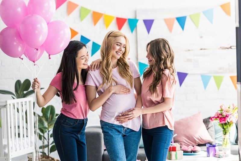 Alles über Babyparty: Spiele, Organisation & Geschenke Frauen berühren schwangeren Freund Bauch bei Baby-Party