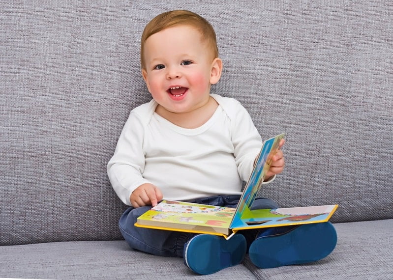 15 Ideen für die Geschenke zum ersten Geburtstag Das einjährige Kind sitzt mit dem Buch