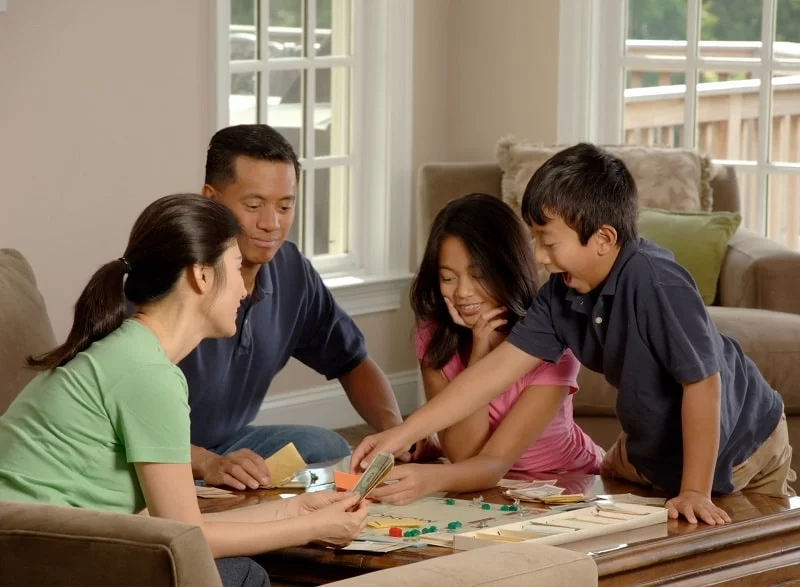 Familie spielt Brettspiele im Wohnzimmer