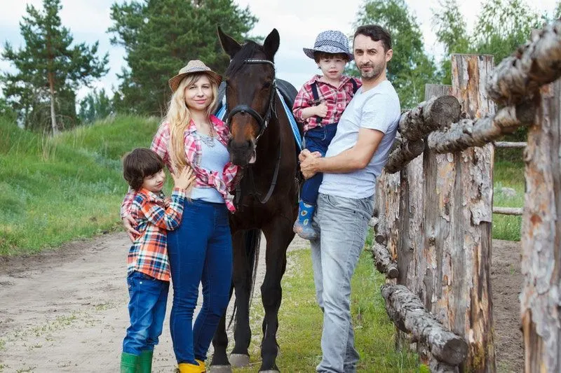 Familie steht neben einem Pferd