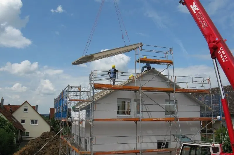Hausbauarbeiter-setzen-ein-neues-Dach