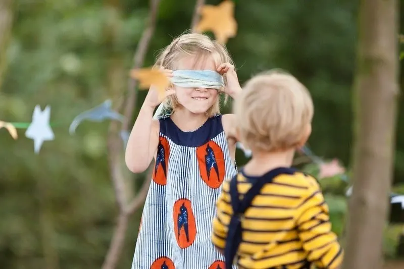 Kinder-spielen-draußen-mit-einer-Augenbinde