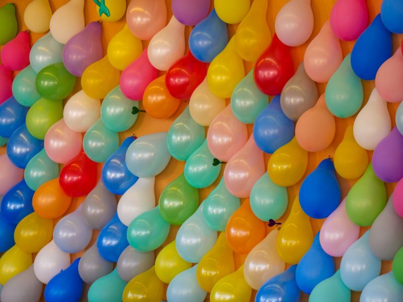 Dutzende Luftballons an der Wand mit Pfeilen