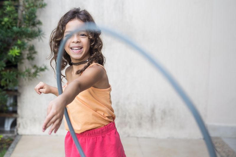 Mädchen spielt mit einem Hula Hoop
