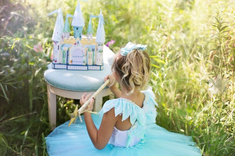 Mädchen als Prinzessin verkleidet spielt draußen
