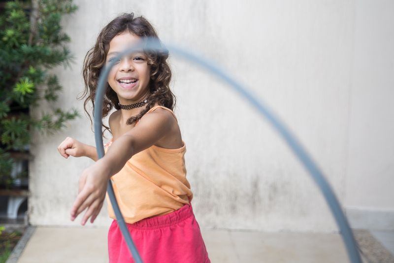 10 Spiele für draußen Mädchen spielt mit einem Hula Hoop