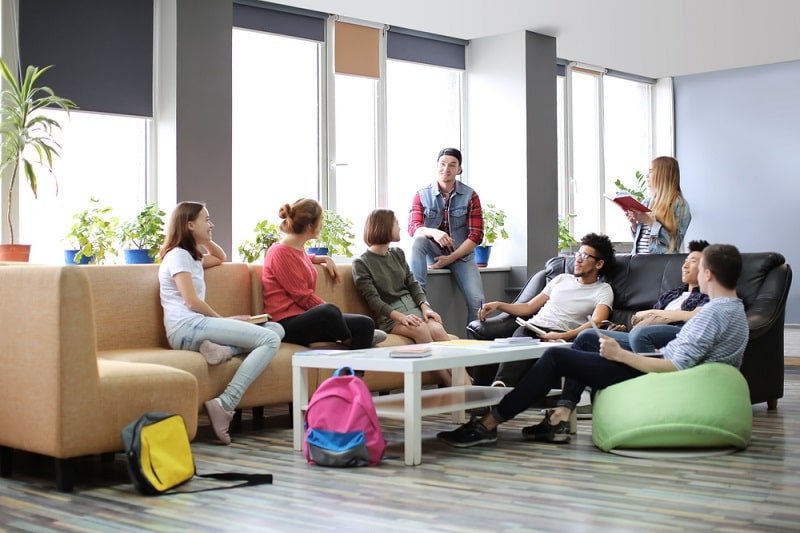 Gesellschaftsspiele für Erwachsene Studenten ruhen sich im Campusgebäude