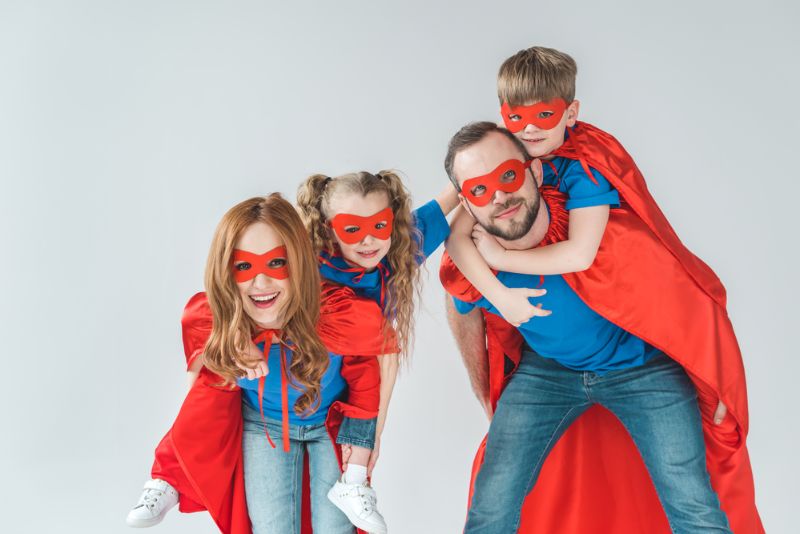 Super Eltern huckepack Kinder, die vorgeben, Superhelden zu sein