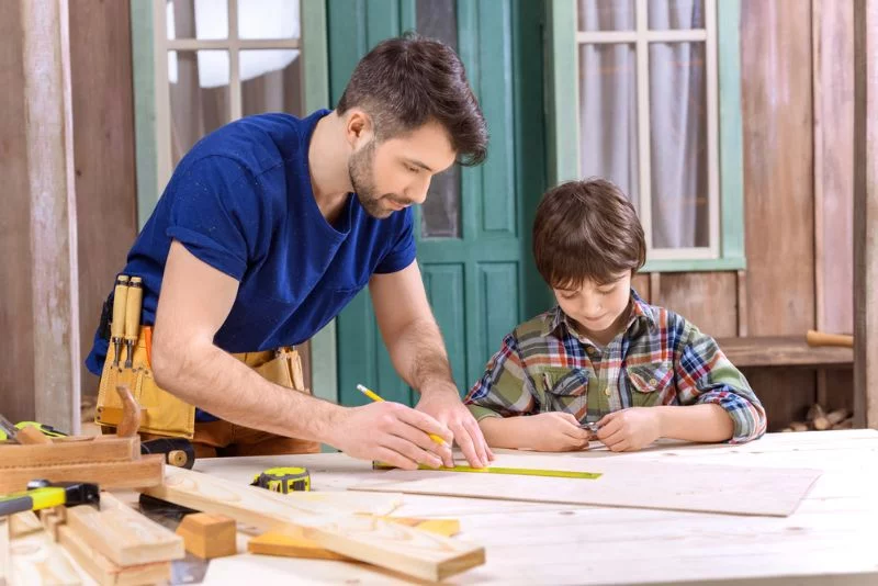 Vater und Sohn in der Werkstatt arbeiten mit Holz