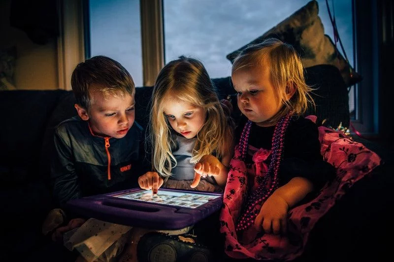 drei Kinder schauen auf ein Tablet