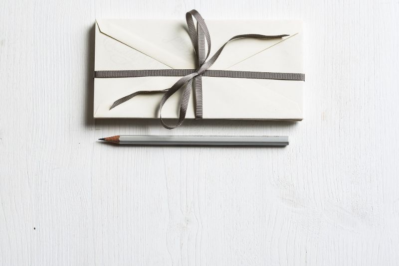 einfacher weißer Einladungsumschlag mit einem Bleistift