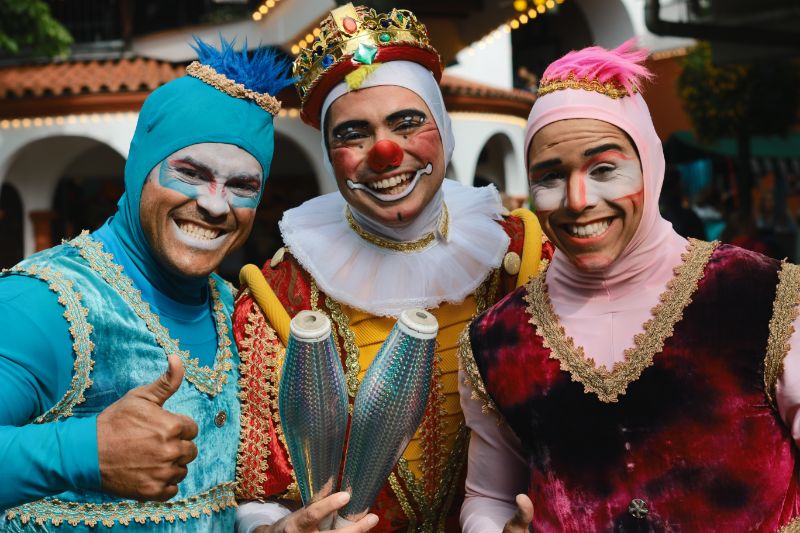 Die bunte Welt der Faschingskostüme Drei Jongleures mit lächelnden Gesichtern