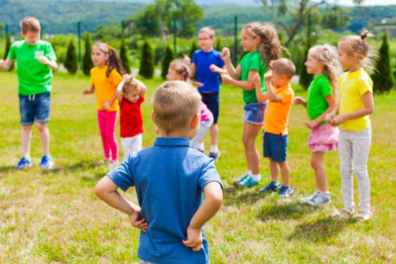 Gruppe von Kindern, die draußen stehen und Spiele spielen