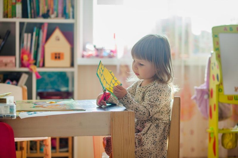 Die 10 Besten Kennenlernspiele Grundschule kleines Mädchen sitzt am Tisch und bastelt