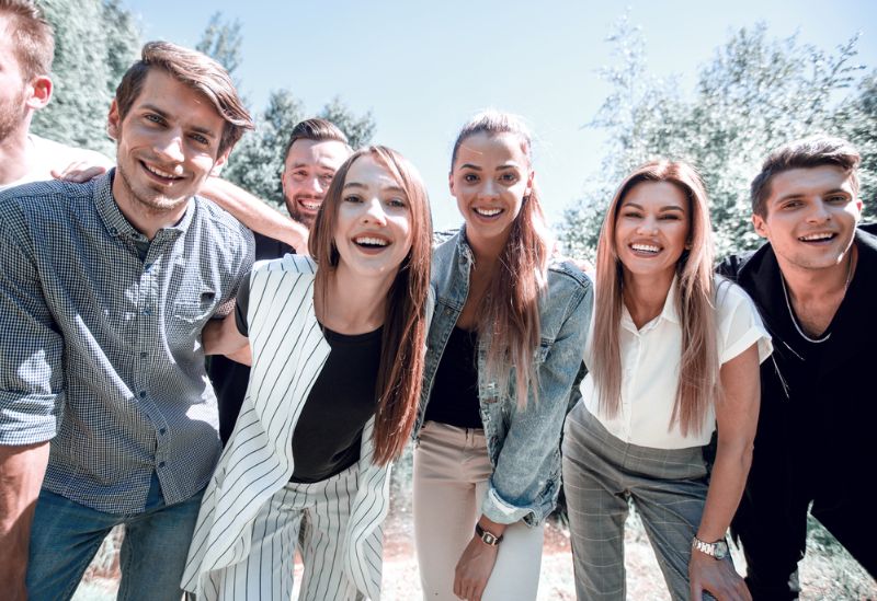 Gruppenspiele für Erwachsene, Jungengruppen und Kinder Team im Business Casual Outfit draußen stehen