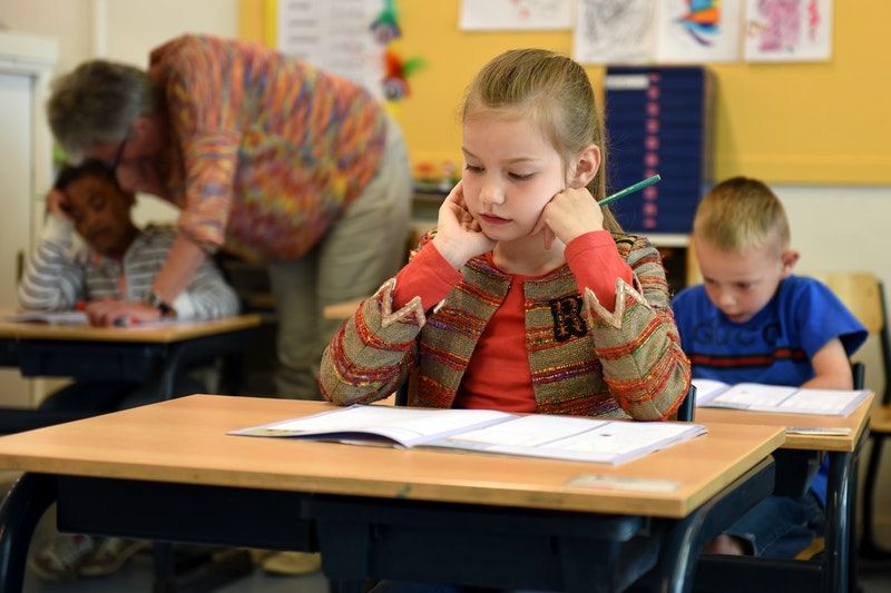 Die 10 Besten Kennenlernspiele Grundschule kleines Mädchen sitzt im Klassenzimmer