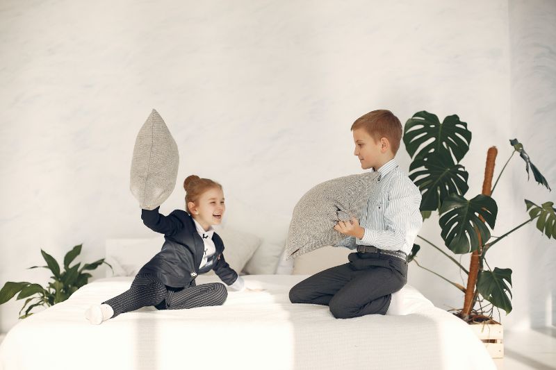 Glückliche-kleine-Kinder-die-Spaß-zusammen-während-Kissenreise-haben