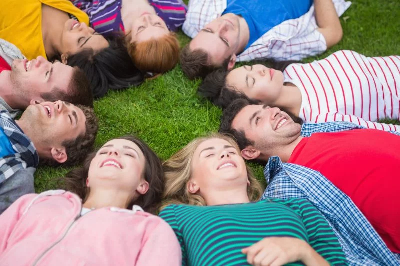 Gruppe von Freunden die im Park liegen