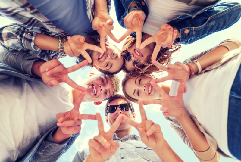 Erlebnispädagogik Spiele: Anleitung Und Elemente Gruppe von Teenagern die Finger fünf Geste zeigen