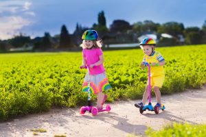 Kinder-die-Roller-am-sonnigen-Sommertag-fahren