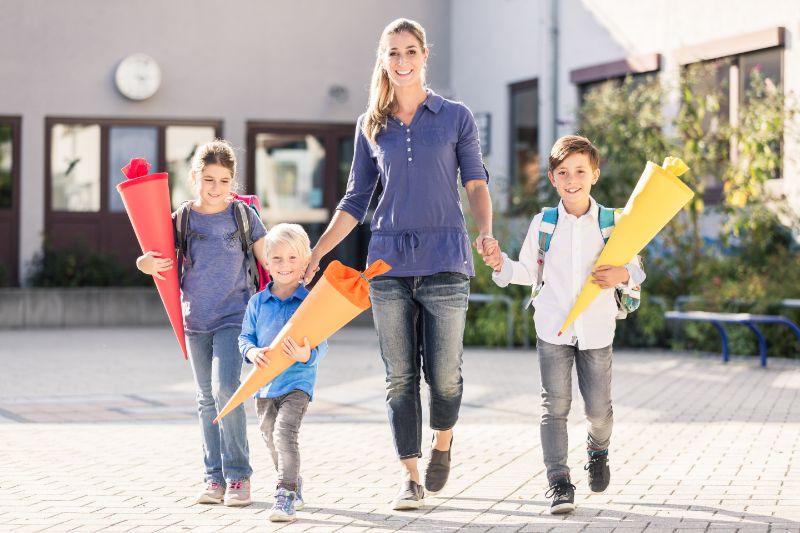 Zuckertüte - Ideen, Tipps und alles über das bunte Wunder Mutter-und-Kinder-mit-Zuckertüte-für-Süßigkeiten-nach-dem-ersten-Schultag
