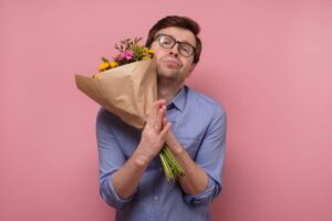 Bitte-vergib-mir-dass-ich-betrogen-habe.-Lustiger-Mann-braucht-Hilfe-oder-Vergebung-von-seiner-Freundin.-Isoliert-auf-rosa-Hintergrund-Studioaufnahme