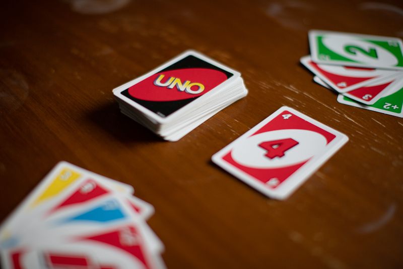 Deck-mit-Uno-Spielkarten-die-überall-auf-einem-Tisch-verteilt-sind.-Amerikanisches-Kartenspiel