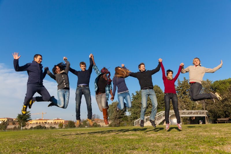 Gruppe-von-glücklichen-College-Studenten-die-am-Park-springen