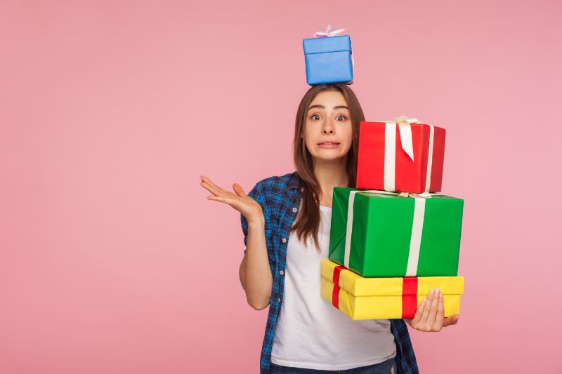 Geburtstag Vergessen: Tipps Und Sprüche Zu Wiedergutmachen Porträt-des-attraktiven-Mädchens-das-Kamera-mit-schuldigem-entschuldigendem-Ausdruck-betrachtet-und-viele-Geschenke-hält-eine-Schachtel-auf-Kopf-Hände-hebend-die-Ausreden-machen.