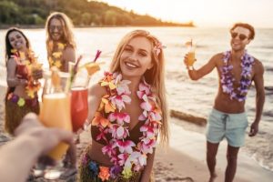 Prost-Eine-Gruppe-junger-attraktiver-Freunde-hat-Spaß-am-Strand-trinkt-Cocktails-und-lächelt.-Party-im-hawaiianischen-Stil.