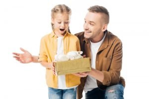 Vater-gibt-einer-geschockten-Tochter-ein-verpacktes-Geschenk