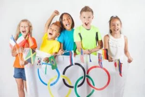 Gruppe-von-Kindern-die-eine-Flagge-von-funf-Ringen-Symbol-der-Olympischen-Spiele-und-der-internationalen-Flaggen-halten.