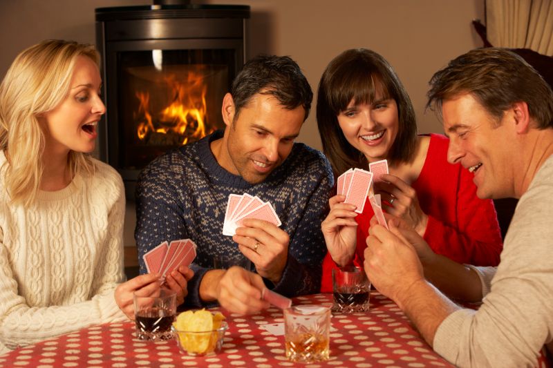 Gruppe-von-Paaren-des-mittleren-Alters-die-Karten-zusammen-spielen