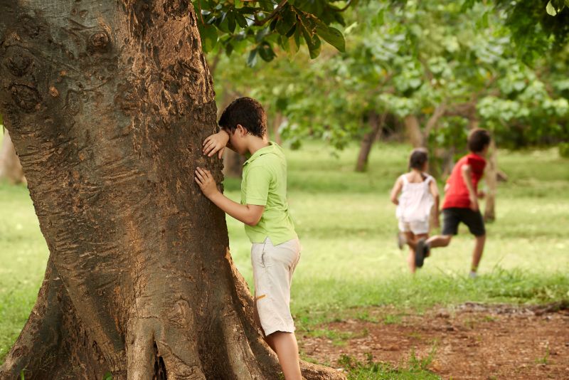 männliche-und-weibliche-Kinder-spielen-Verstecken
