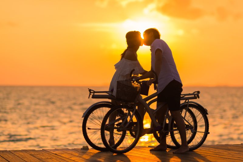romantisches-Paar-Fahrrad-fahren-im-Sonnenuntergang
