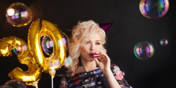 Junge-attraktive-blonde-Frau-feiert-ihren-30.-Geburtstag.-Schone-frohliche-Blondine-mit-goldenen-Luftballons.-Geburtstag