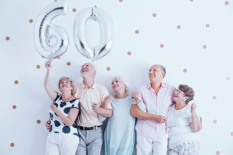 Grosmutter-und-Grosvater-mit-silbernen-Luftballons-feiern-60.-Geburtstag