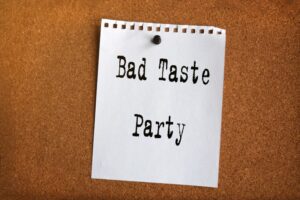 Papiernotiz-mit-der-Aufschrift-BAD-TASTE-PARTY-auf-Korkplatte
