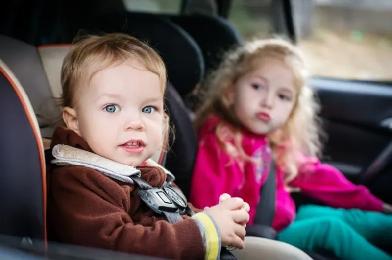 Kleine-Kinder-in-Autositzen-im-Auto