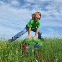 Gluckliche-gesunde-Kinder-die-im-Sommer-im-Freien-Bockspringen-spielen