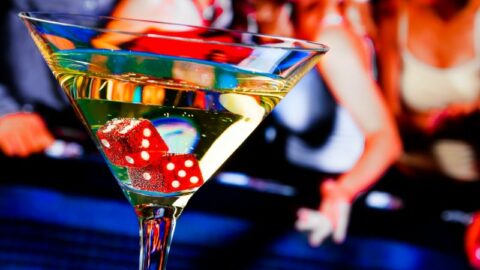 Rote Würfel im Cocktailglas vor dem Glücksspiel