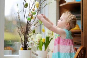 Kleines Mädchen, das nach Hause für Ostern verziert
