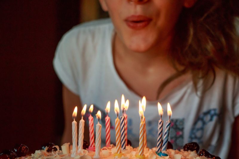 Mädchen bläst Kuchen Kerzen aus
